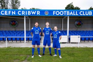 Three proud Footballers pose in their new kit